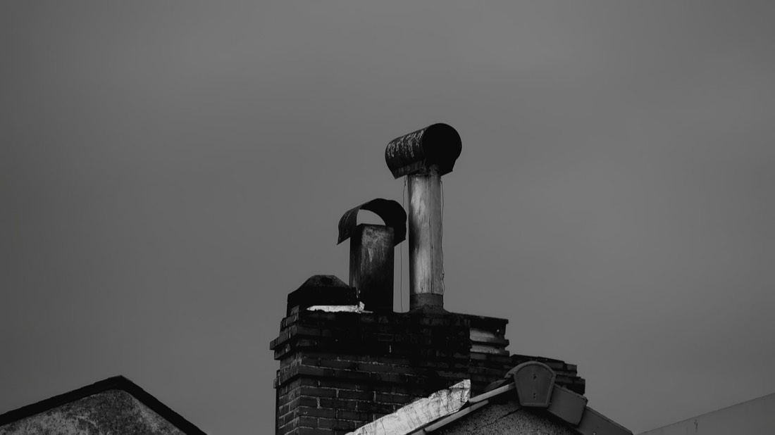 Conduits de cheminée sur un toit ancien, photographie en noir et blanc